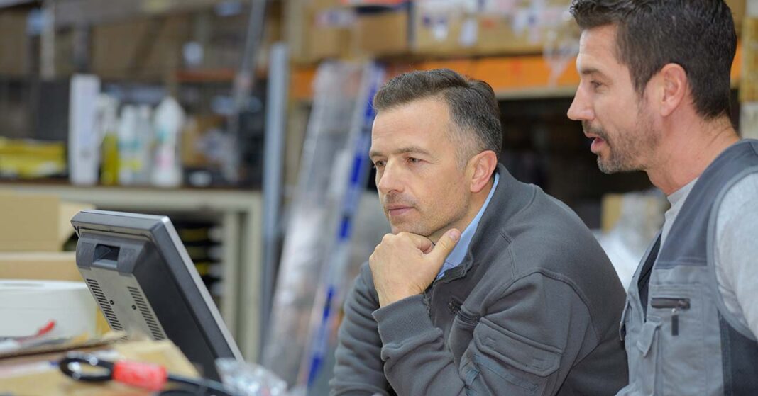 probaido-alatti-szabadsag Két férfi képernyőt néz egy kékgalléros munkahelyen