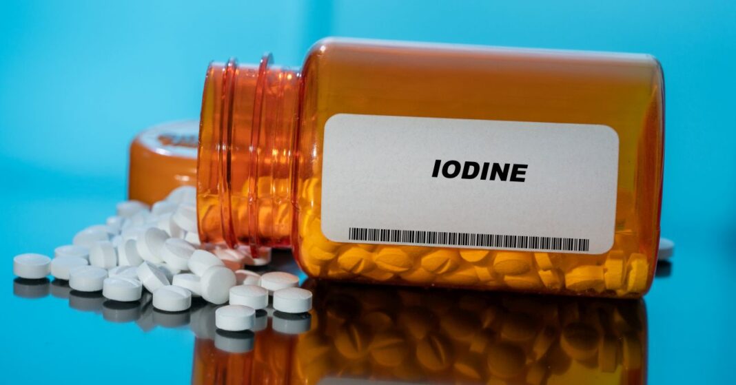 iodine white medical pills and tablets spilling out of a drug bottle. Macro top down view with copy space. jódtabletta kiborulva a gyógyszeres dobozból