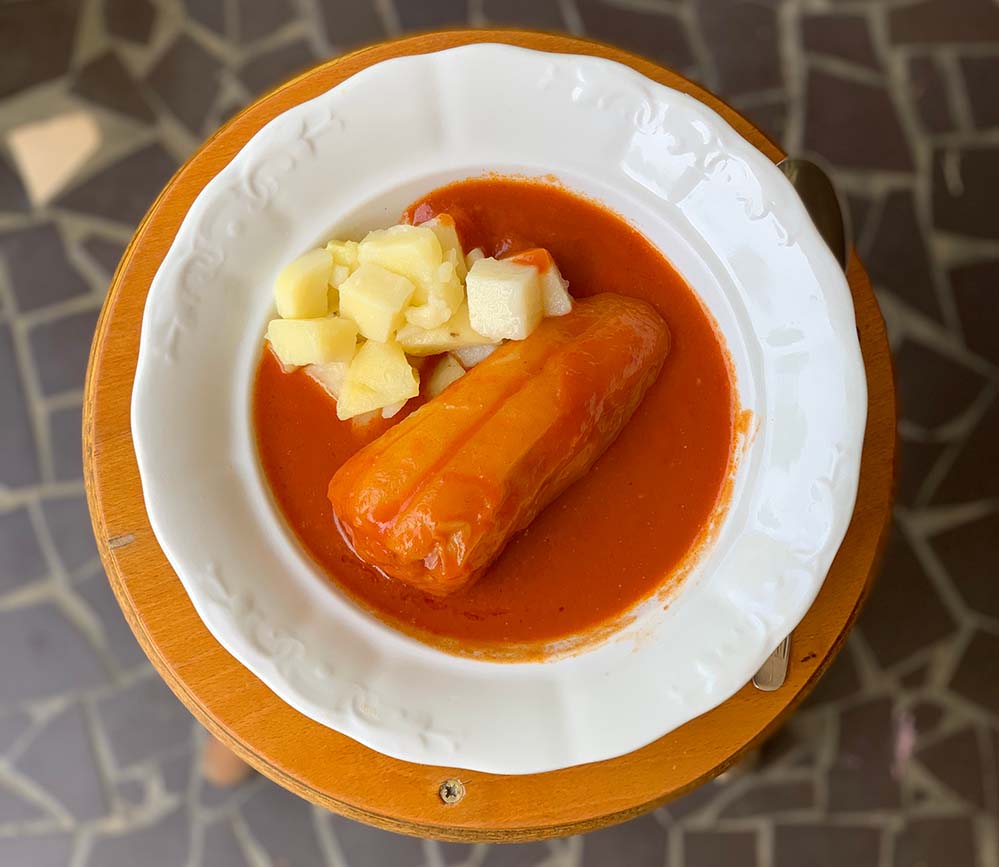 Töltött paprika fehér tányéron, kerek kissámlin