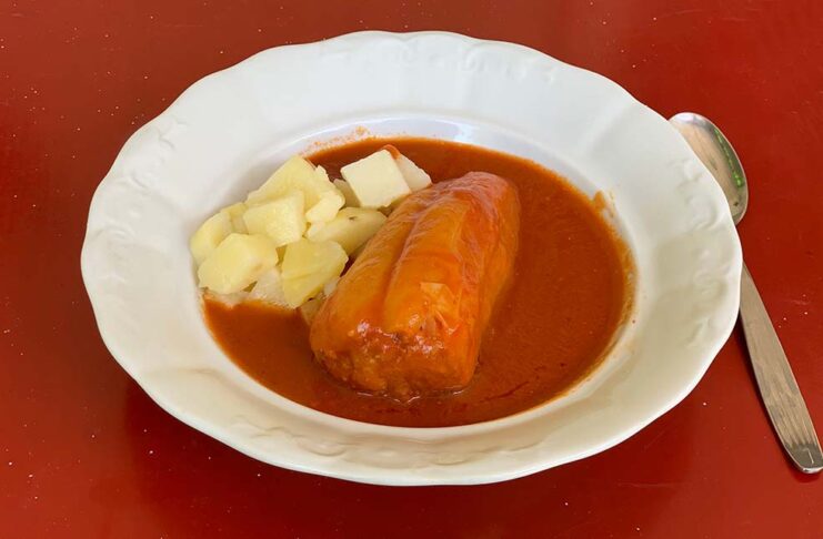 Töltött paprika fehér tányéron, piros asztalon