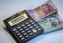 számológép mellett 20.000 és 10.000 forintos bankjegyek stócban