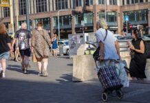 nyugdíjasok az utcán, egyikük banyatankkal