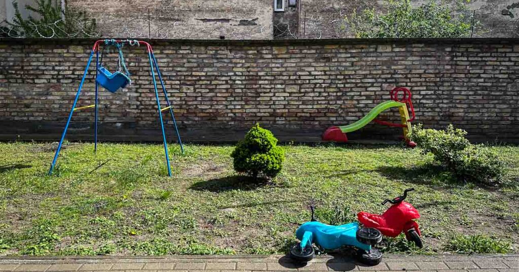 játszótér hintával, két elhajított kismotorral