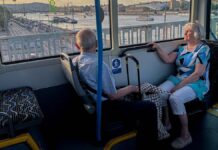 nyugdíjas pár ül egymással szemben a BKK egyik járatán