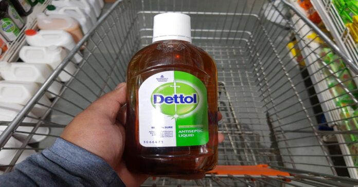 Egy Dettolt tartó férfi kéz a bevásárlókocsi felett