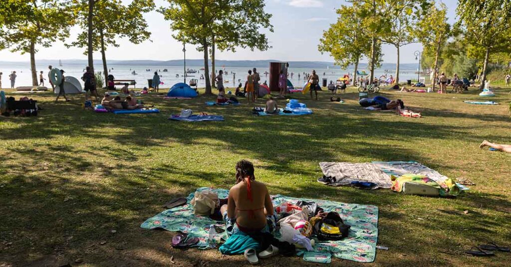 nyaralók a Balaton pártján napoznak