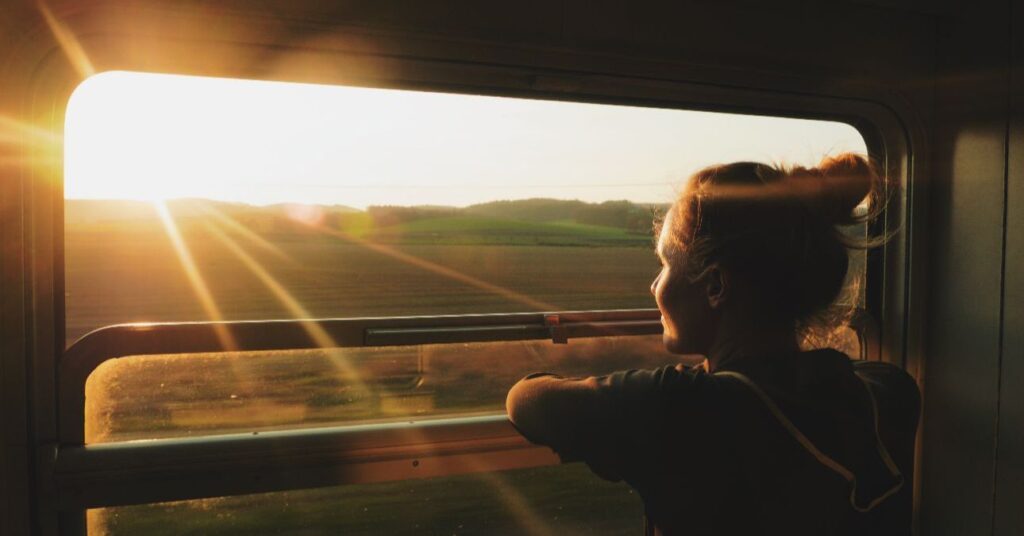 fiatal nő néz ki a vonat nyitott ablakán