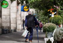 idős férfi bottal, szatyorral a Lidl felé tart