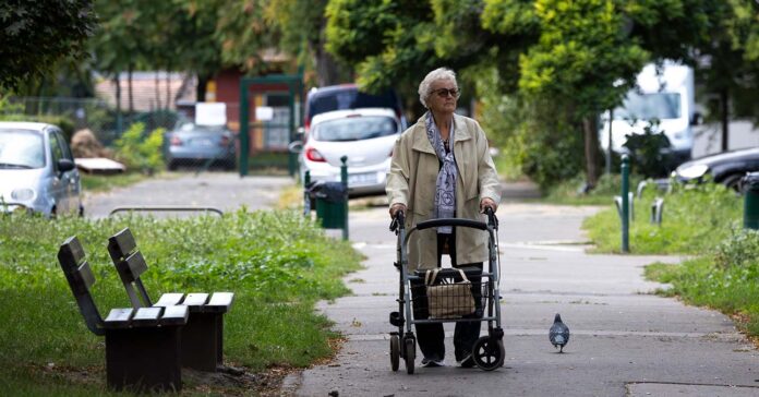nyugdíjas nő rollátorral sétál