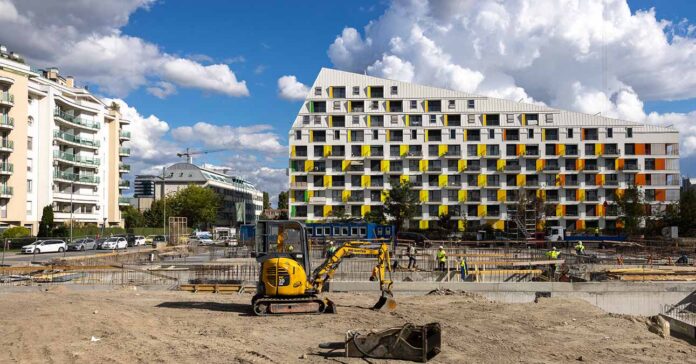 új társasházak épülnek, építési területen sárga munkagép