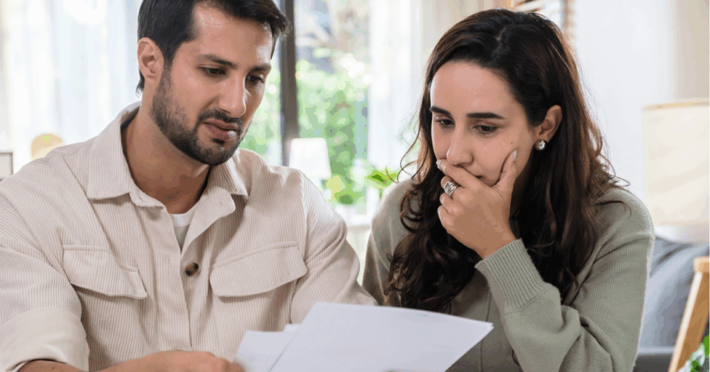 fiatal férfi és nő szörnyülködve néznek egy számlát - rezsitartozás