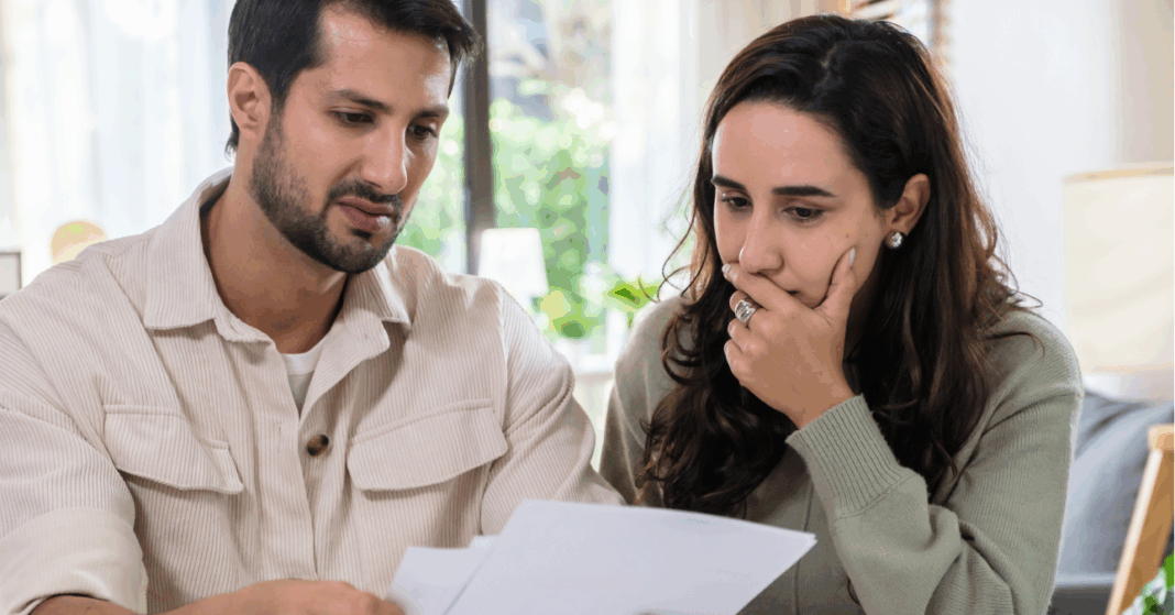 fiatal férfi és nő szörnyülködve néznek egy számlát