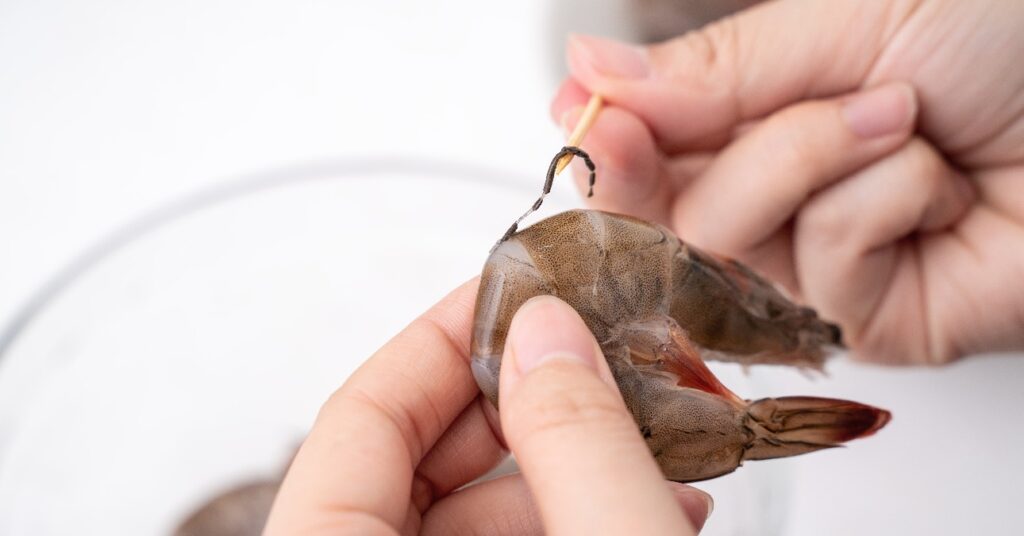 egy nő garnélát tisztítót fogpiszkálóval