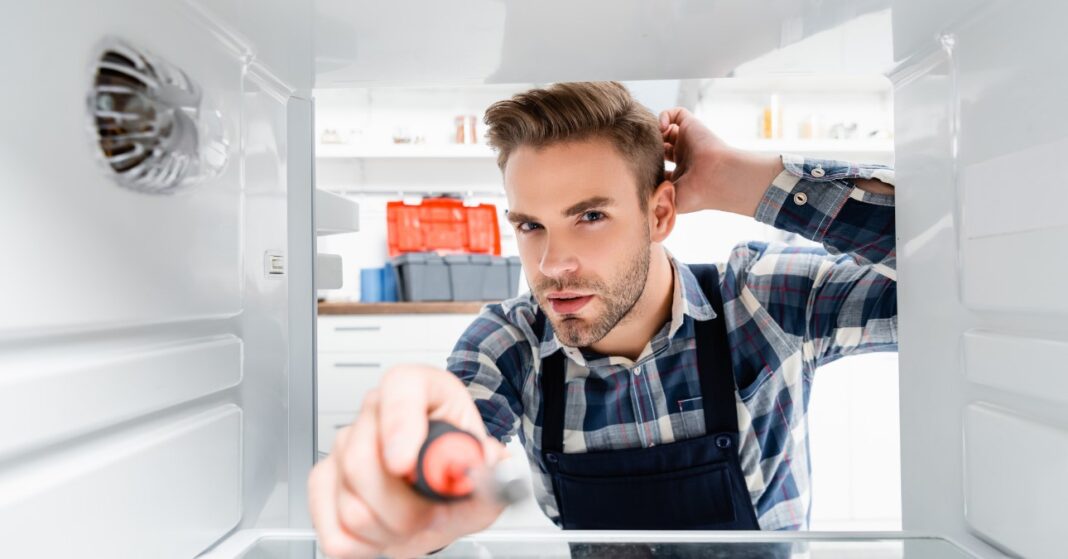 férfi szereli a hűtőt