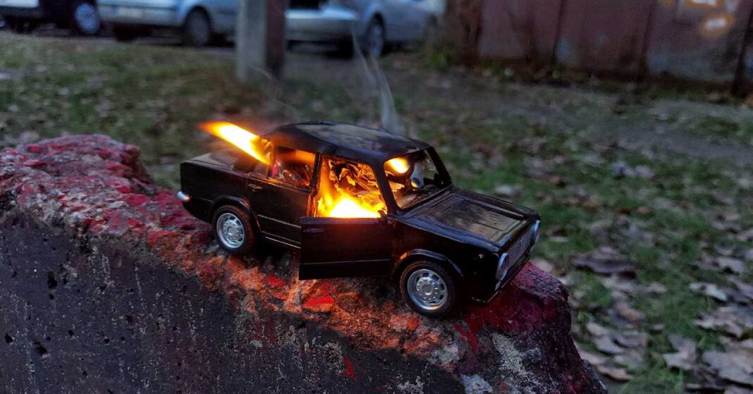 kigyullad játékautó, a háttérben zöldterület, parkoló autók