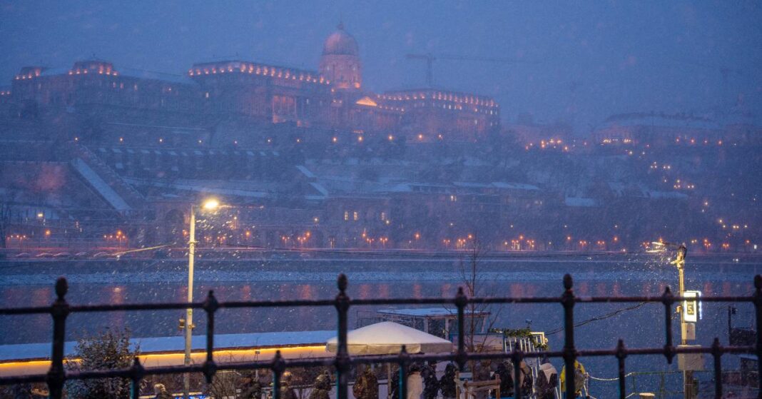 Budapest télen 2026 januárjában, esti hóesés, háttérben a Budai Vár és a Duna