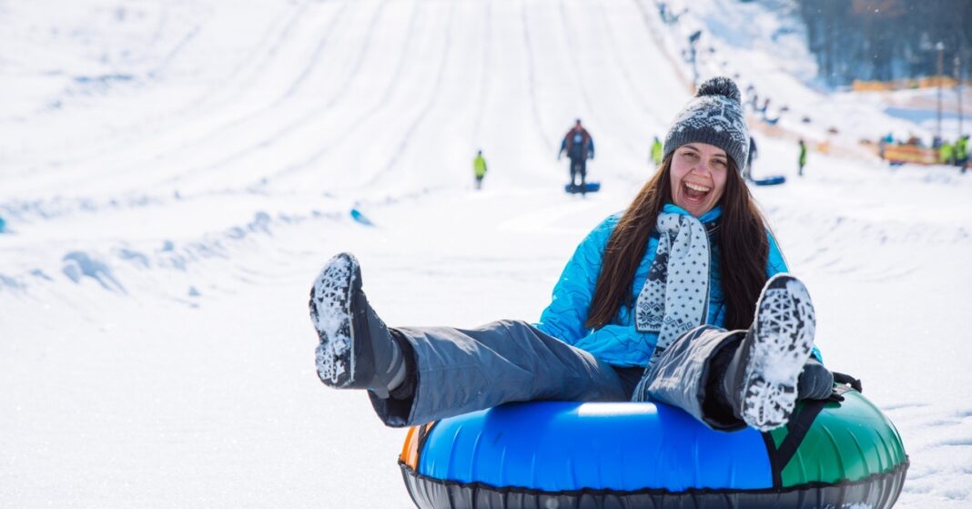 egy nő boldogan mosolyog szánkózás közben
