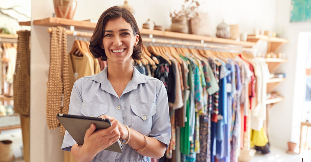 Egy női vállalkozó a boltjában, tablettel a kezében