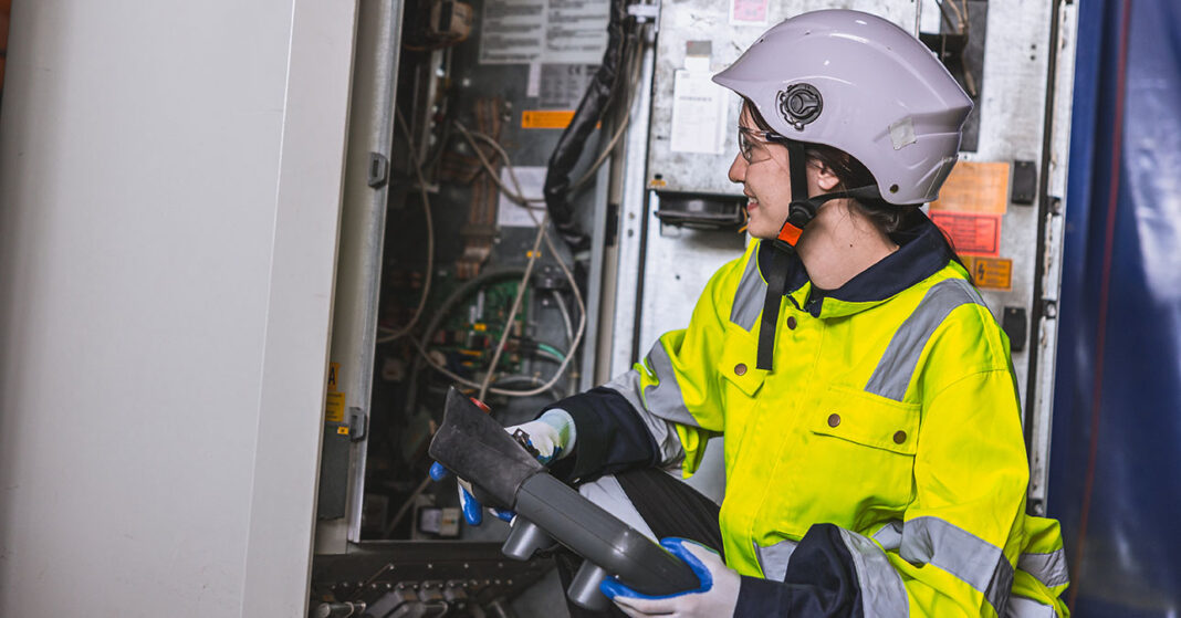 Női villanyszerelő ellenőrzi a villanyóra bekötését