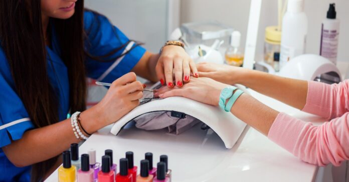 műkörmös nő körmöt díszít