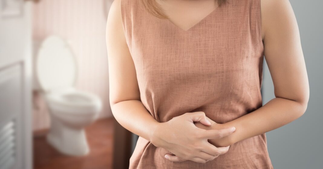 Egy nő a hasát fogja, háttérben egy wc