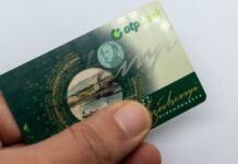 egy férfi kézében SZÉP-kártya, hüvelyujjal letakarva az adatok