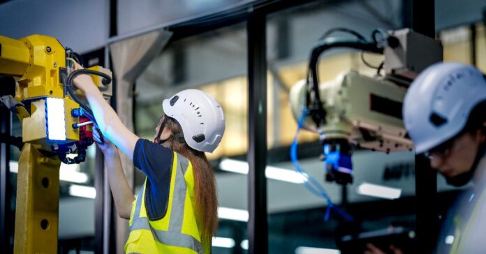 Két robotikai mérnöknő egy K+F (kutatás-fejlesztési) laboratóriumban egy mesterséges intelligenciával működő kobotot (együttműködő robotot) tesztel. Éppen a robotrendszer hardverét, szenzorait és programozását ellenőrzik.