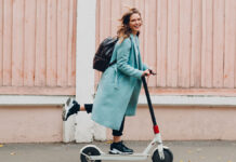 Nem éri meg trükközni: a kötelező biztosítás e-rollerre ennyibe kerül – mutatjuk az árakat Fiatal nő kék kabátban elektromos rolleren utazik