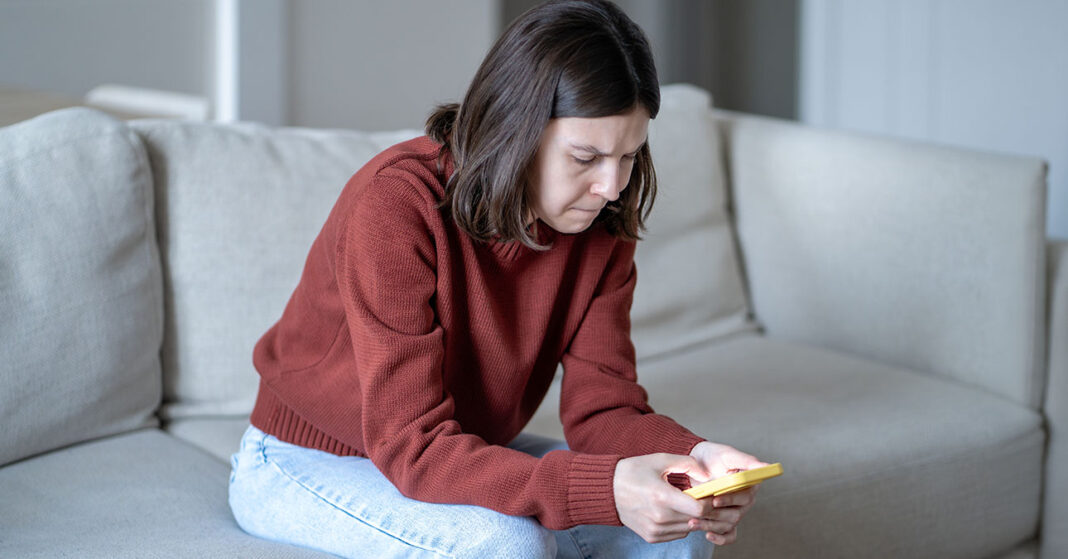 Kiégett millenniál nő a telefonját nyomkodja